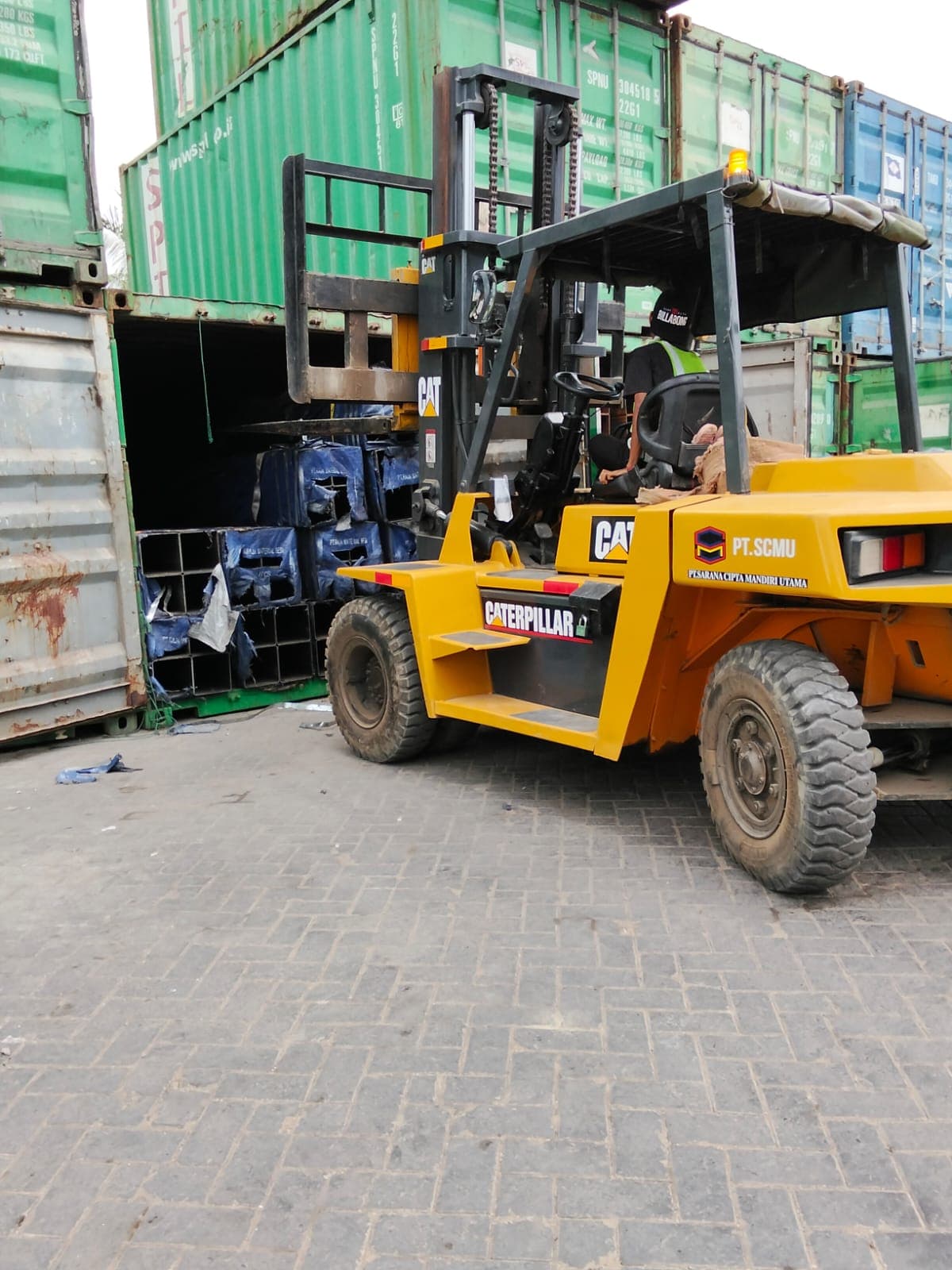 Forklift SCMU memindahkan drum di antara kontainer dan truk