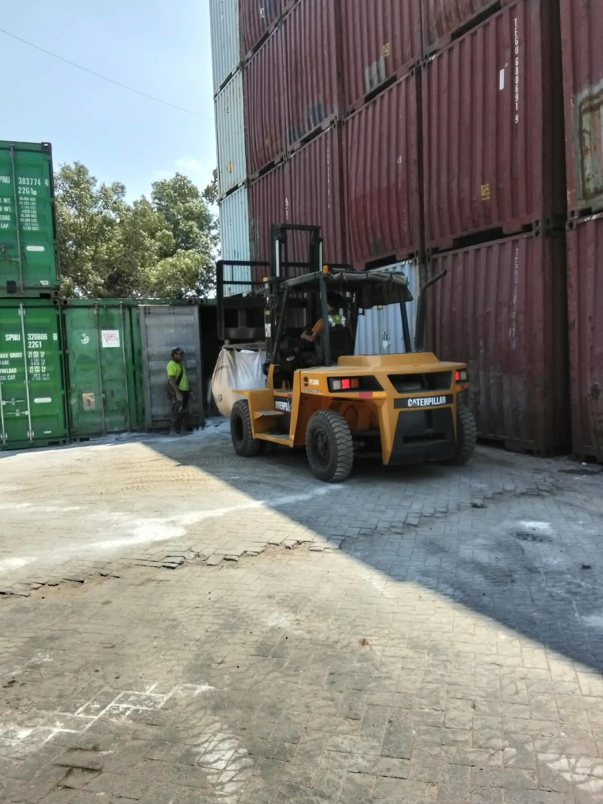 Forklift CAT membawa muatan bulk bag di area depo kontainer