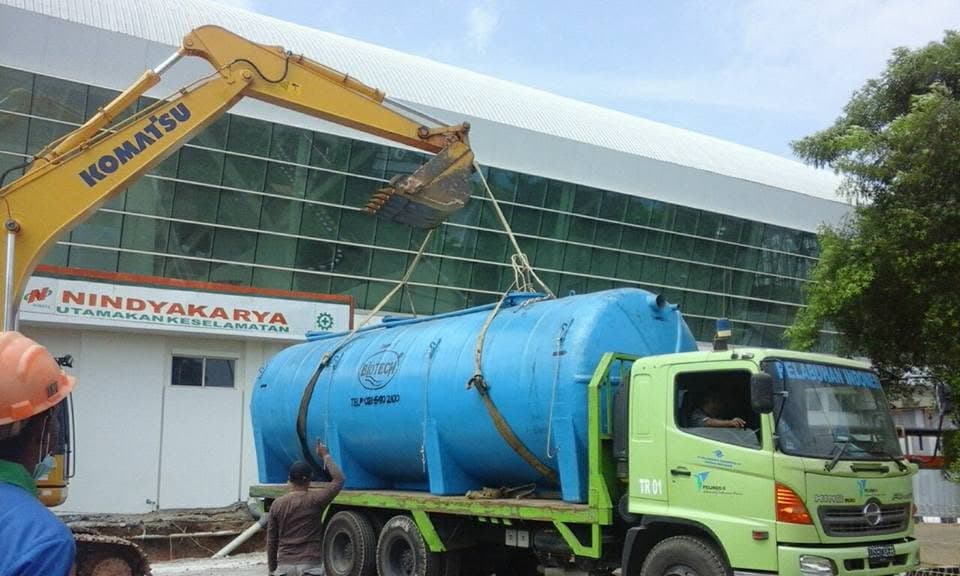 Tangki industri berukuran besar diangkat ke atas truk flatbed
