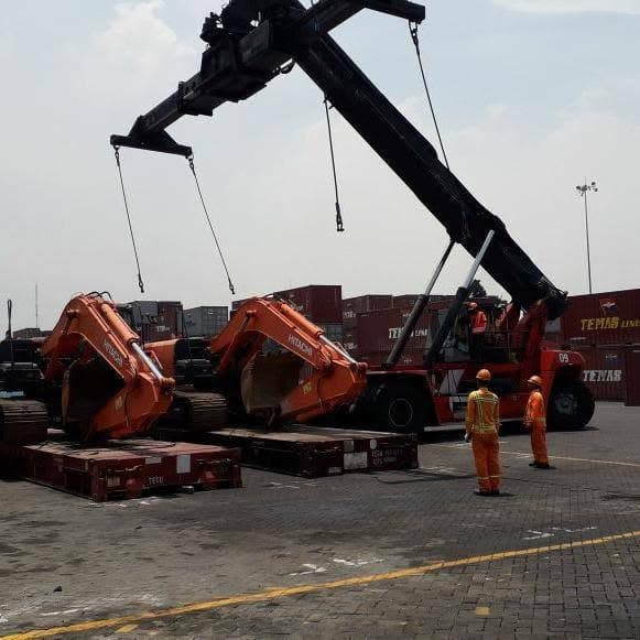 Alat angkat memindahkan dua ekskavator ke atas flat rack